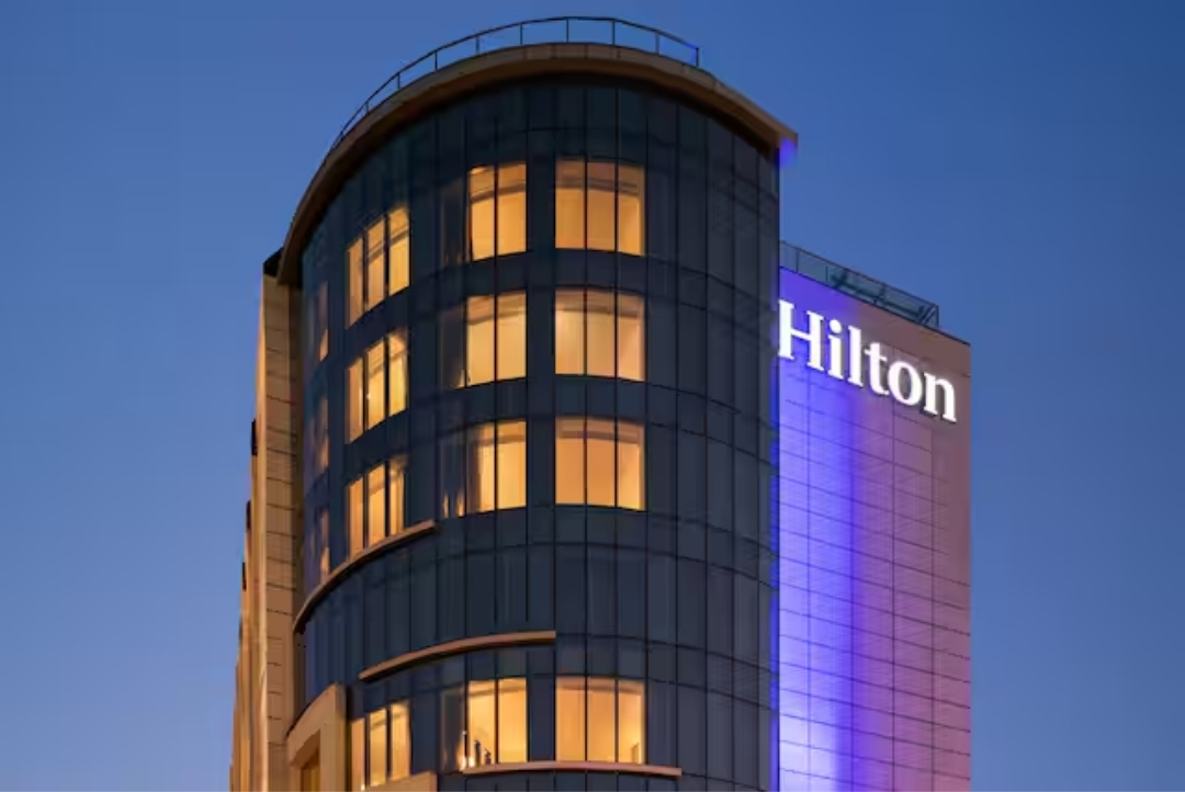 Hilton Jaipur — illuminated hotel tower at dusk