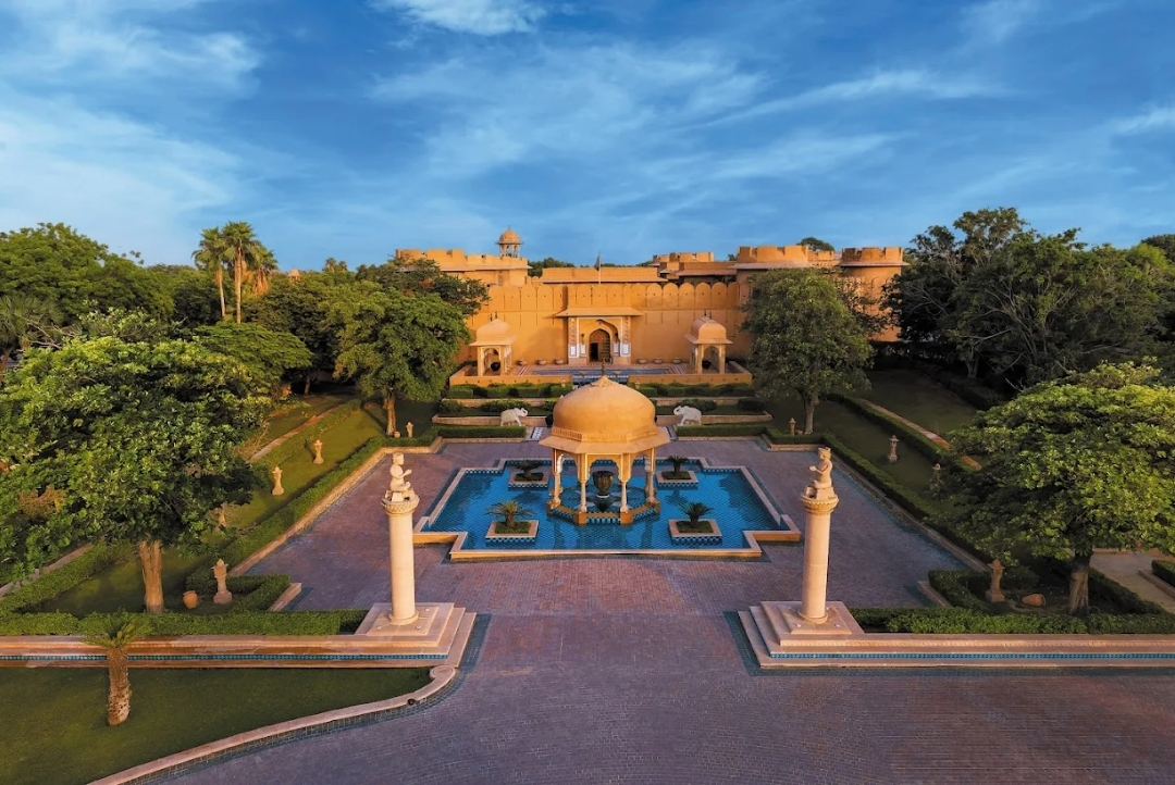 The Oberoi Rajvilas, Jaipur — aerial view of the fort-style main building and central reflecting pool