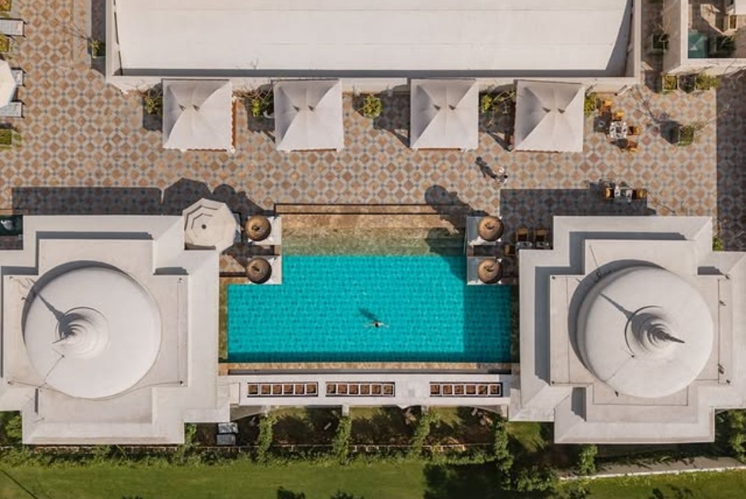 Aerial view of the swimming pool and cabanas at Raffles Jaipur