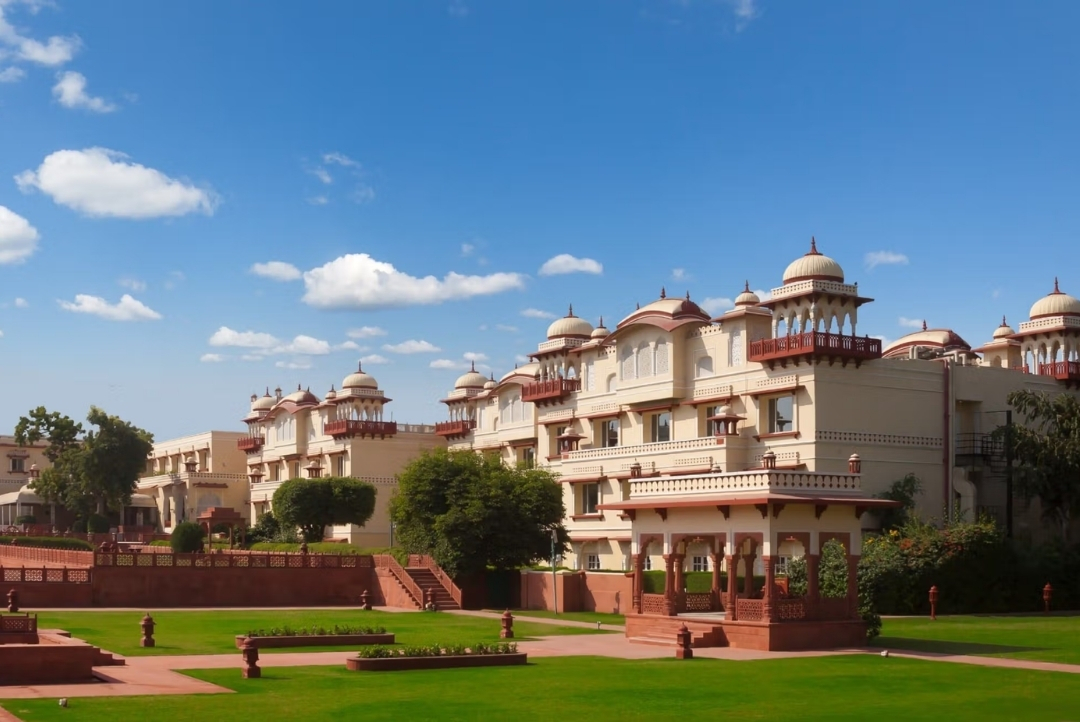 The Indo-Saracenic palace façade and manicured lawns — Jai Mahal Palace, Jaipur