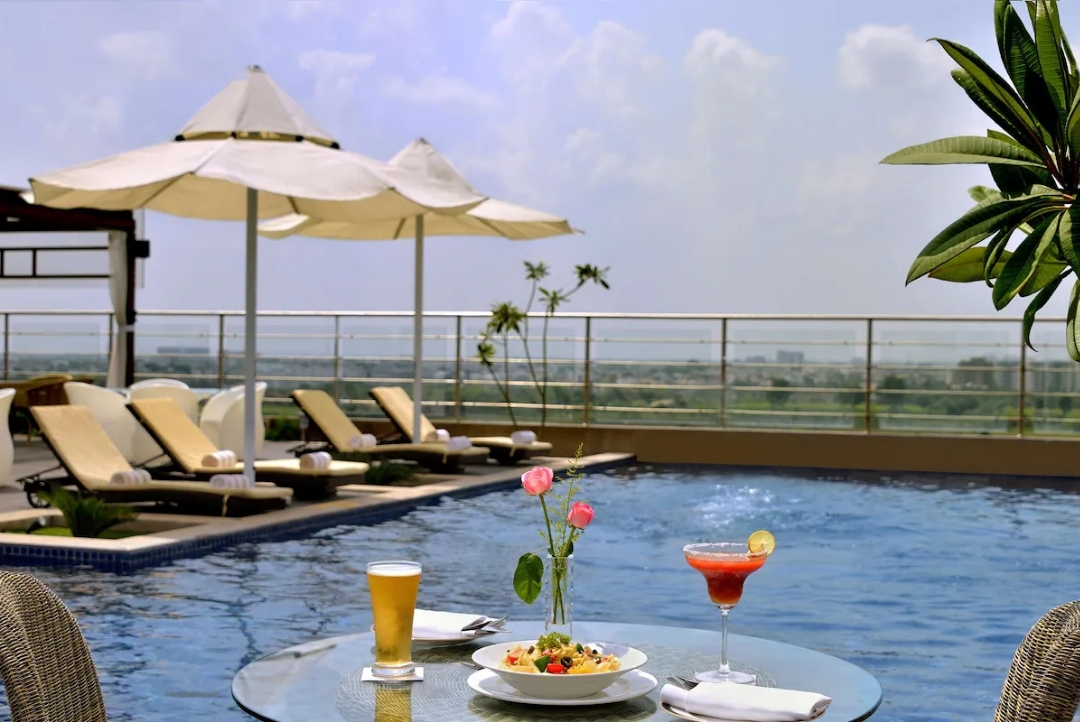 Poolside loungers on the rooftop deck — Radisson Blu Jaipur