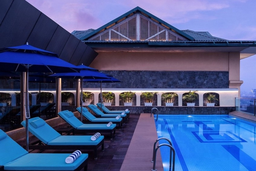 Rooftop swimming pool at dusk — Radisson Jaipur City Center
