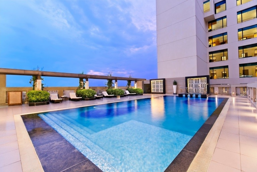 Rooftop swimming pool at dusk — The LaLiT Jaipur