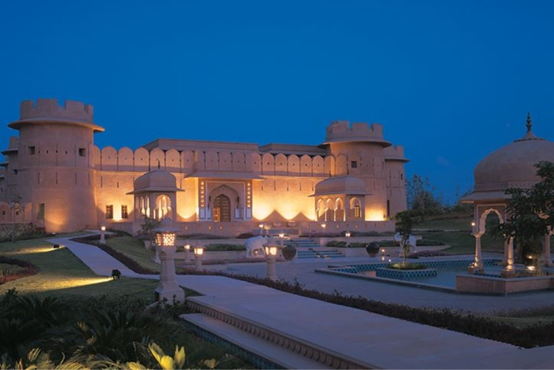 The Oberoi Rajvilas, Jaipur — illuminated fort facade at dusk