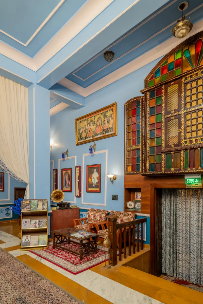 A sitting corner at Kurki Palace with a gramophone, stained-glass windows and paintings on blue walls